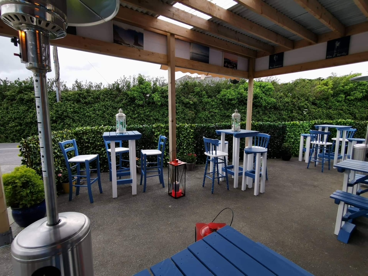 Blue and white high tables under the covered terrace at Pisces