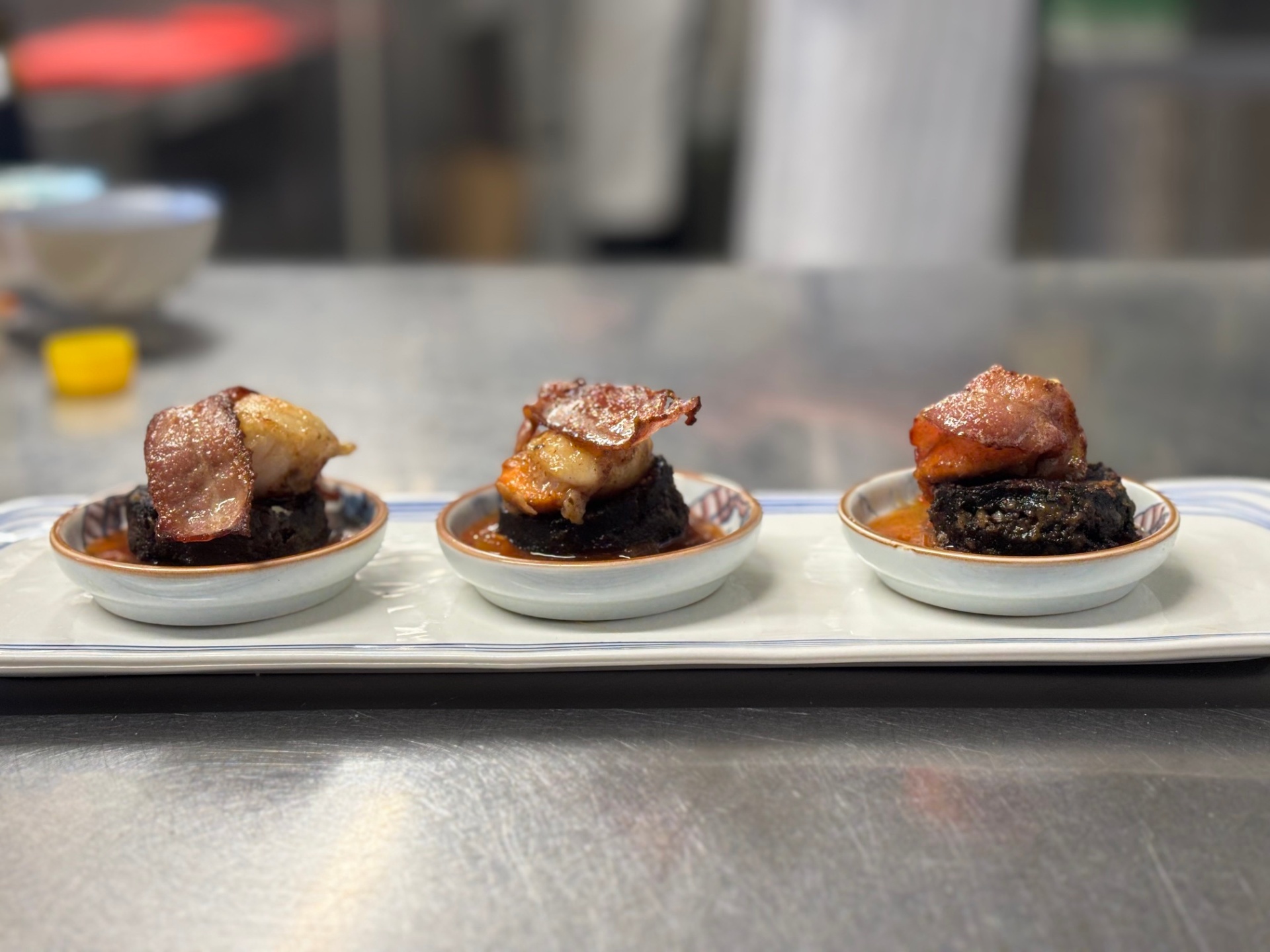 Seared scallops on black pudding with crispy bacon